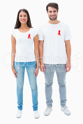 Attractive young couple wearing aids awareness ribbons