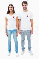 Attractive young couple wearing aids awareness ribbons