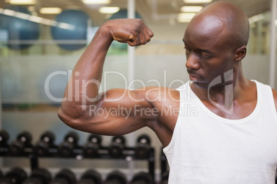 Muscular man flexing muscles in gym