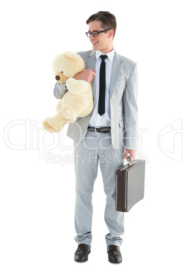 Handsome businessman holding briefcase and teddy