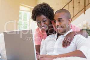 Cute couple relaxing on couch with laptop