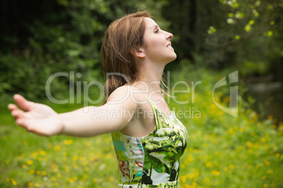 Woman with arms outstretched in field