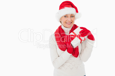 Festive woman smiling at camera holding a gift