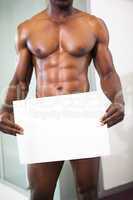 Muscular man holding blank board