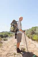 Handsome hiker smiling at camera in the countryside