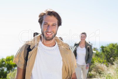 Hiking couple smiling at camera on mountain summit