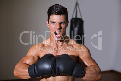 Muscular boxer shouting in health club