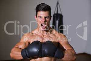 Muscular boxer shouting in health club