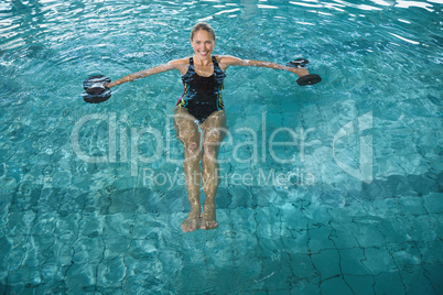 Fit blonde working out with foam dumbbells