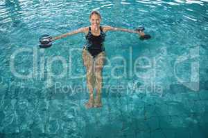 Fit blonde working out with foam dumbbells