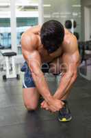 Muscular man flexing muscles in gym