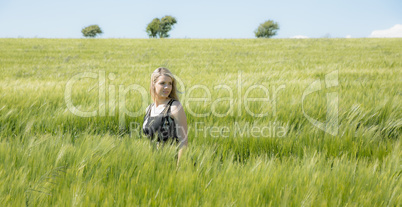 Pretty blonde in sundress standing in wheat field