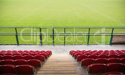 Red bleachers looking down on football pitch