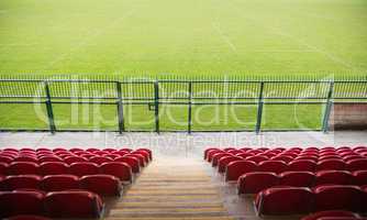 Red bleachers looking down on football pitch