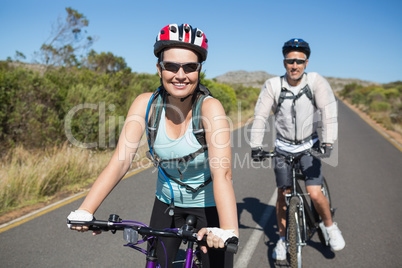 Fit happy couple going for a bike ride in the countryside