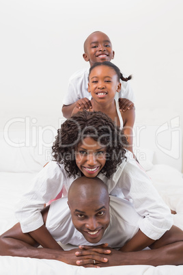 Happy family posing together in bed