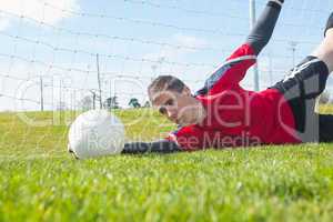 Goalkeeper in red making a save