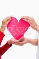 Couples hands holding pink heart