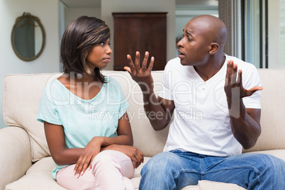 Unhappy couple having an argument on the couch