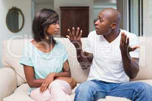 Unhappy couple having an argument on the couch