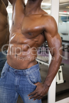 Mid section of a shirtless muscular man in gym