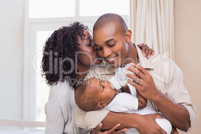 Happy parents feeding their baby boy a bottle