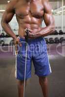 Muscular man using resistance band in gym