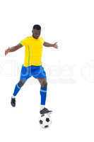 Football player in yellow kicking ball