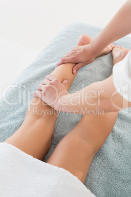 Woman receiving leg massage at spa center