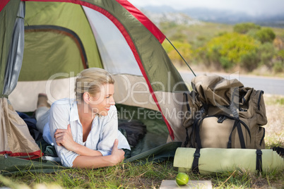 Attractive happy blonde lying in tent