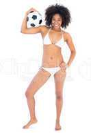 Happy fit girl in white bikini holding football