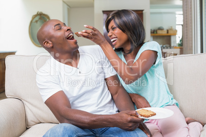 Happy couple relaxing on the couch with toast