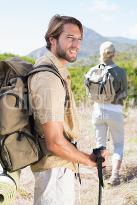 Attractive hiking couple walking on mountain trail