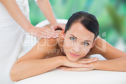 Beautiful brunette enjoying a back massage smiling at camera