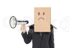 Businessman with box on head holding megaphone