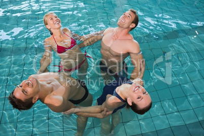 Happy fitness class stretching in aqua aerobics