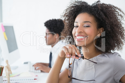 Young editor smiling at camera at her desk