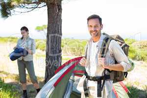 Outdoorsy couple setting up camp in the countryside