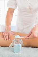 Beauty therapist using salt scrub