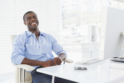 Happy businessman sitting at his desk