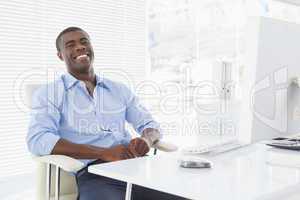 Happy businessman sitting at his desk