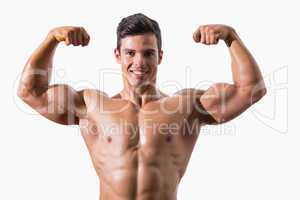 Portrait of a muscular young man flexing muscles