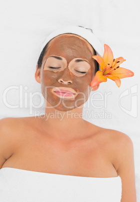 Smiling brunette getting a mud treatment facial