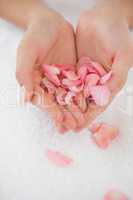 Woman holding pink rose petals