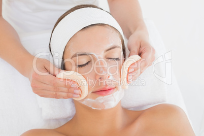 Hand cleaning womans face with cotton swabs