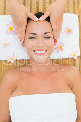 Smiling brunette enjoying a head massage