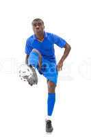 Football player in blue kicking ball