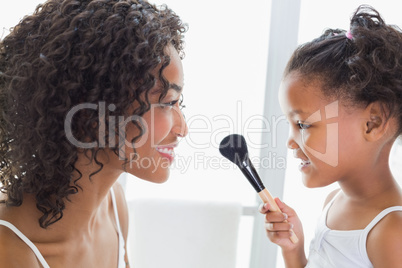 Pretty mother teaching her daughter about makeup