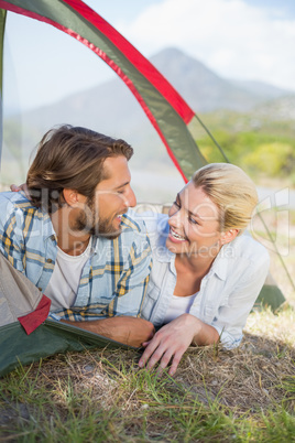 Attractive couple smiling at each other from inside their tent