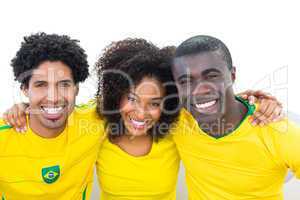 Happy brazilian football fans in yellow sitting on couch